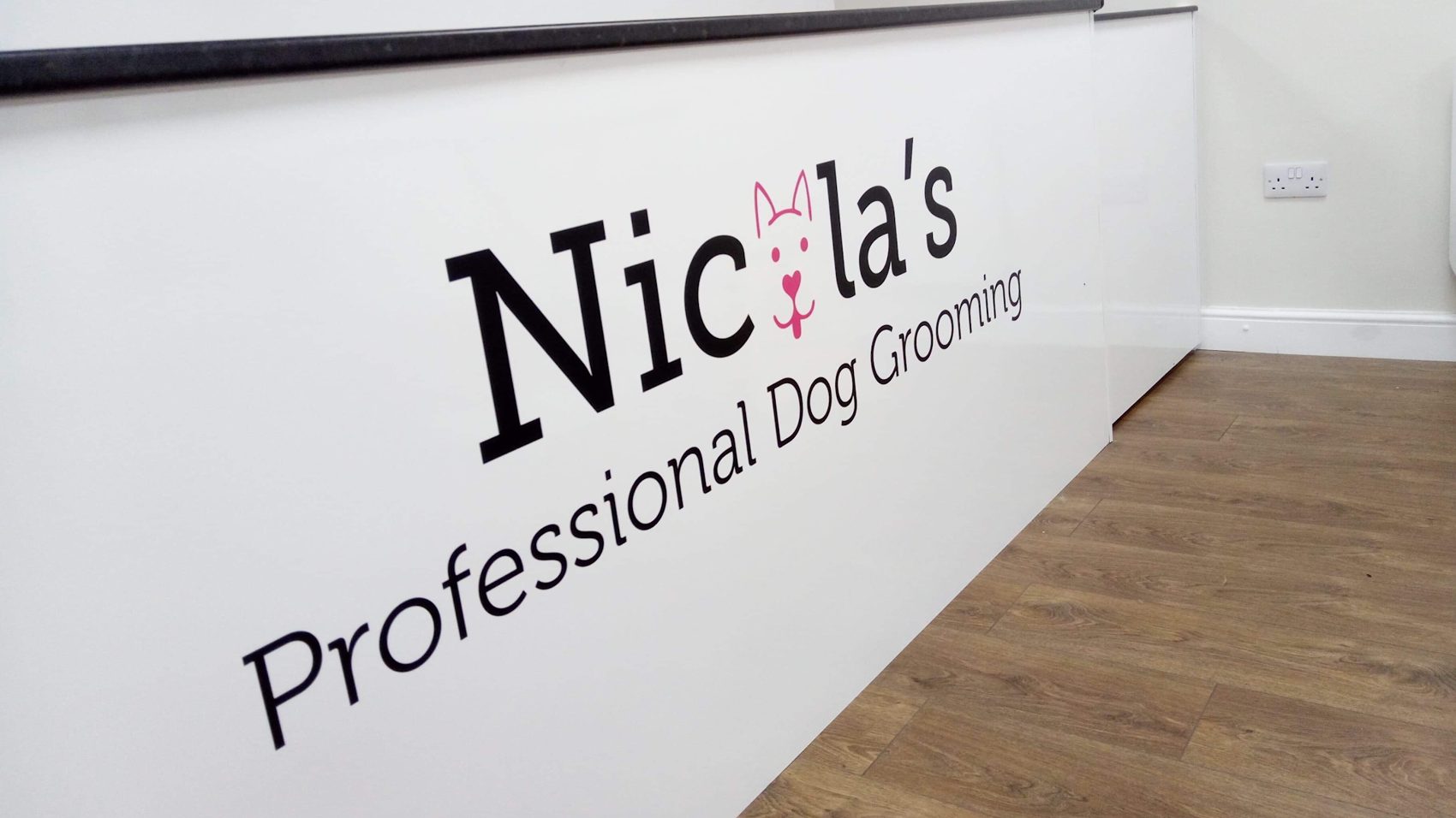 The salon counter with the Nicola's Professional Dog Grooming lettering
